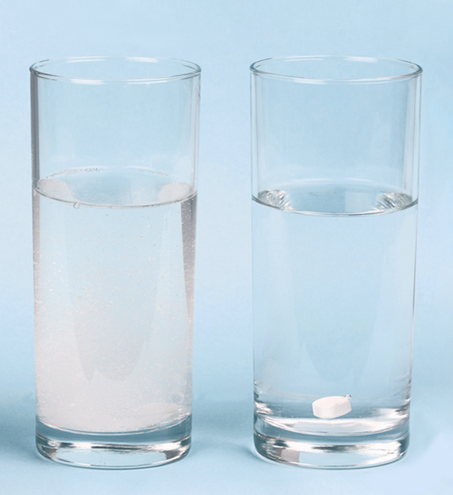 To glass med vann- et med en oppløst Bio-Magnesium-tablett og en med en annen magnesiumtablett som ikke viser tegn til å løses opp